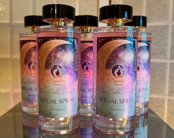 May include: Five clear glass bottles with black and gold lids and labels. The labels are purple, pink, and blue with a crescent moon and stars. The bottles are filled with a clear liquid and have the text "Peace Calm Serenity Ritual Spray 250 ml, 8.5 oz" on the label.