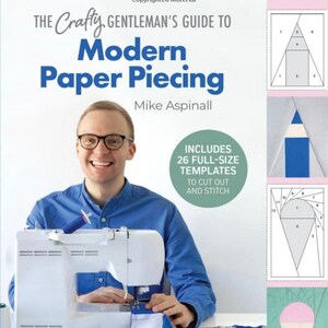 May include: A book cover with a blue background and the title "The Crafty Gentleman's Guide to Modern Paper Piecing" in white text. The cover also features a man in a blue shirt using a sewing machine to sew a quilt. The book includes 26 full-size templates to cut out and stitch.