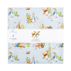 May include: A stack of fabric squares featuring a light blue background with illustrations of Peter Rabbit and Benjamin Bunny. The fabric has images of rabbits, flowers, butterflies, and other nature elements. The text "Riley Blake Designs" and "Peter Rabbit and Benjamin Bunny" are visible.