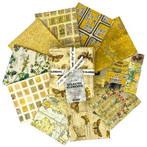 May include: A set of 12 fabric squares featuring a variety of vintage-inspired patterns in shades of yellow and cream. The patterns include butterflies, maps, botanical illustrations, and numbers. The fabric squares are packaged together with a label that reads "Eclectic Elements".