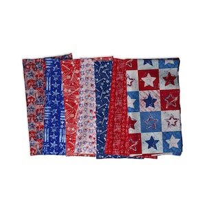 May include: A collection of patriotic-themed fabric pieces in red, white, and blue. The fabrics feature star patterns, stripes, and checkered designs. Ideal for crafting or decorative projects.
