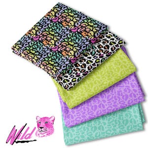 May include: A stack of five fabric squares with a leopard print pattern in various colors, including pink, green, purple, and black. The fabric squares are arranged in a pyramid shape, with the largest square at the bottom and the smallest square at the top. The fabric squares are all made of a soft, cotton material. The word "Wild" is written in pink letters on a black background in the lower left corner of the image. A cartoon leopard head is to the right of the word "Wild".