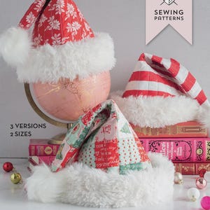 May include: Three Santa hats in different patterns, including red floral, red and white stripes, and patchwork designs, with white faux fur trim. The hats are displayed with a pink globe and books. The text reads "The Snowbound Hat" and "A Quilted Santa Hat Sewing Pattern."