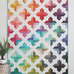 May include: A colorful quilt with a trellis pattern. The quilt features a repeating cross design in various colors, including orange, red, pink, blue, and green. The text "Trellis" is at the top, and "Cluck Cluck Sew" is at the bottom left. The text "A Jelly Roll, Layer Cake, or Fat Quarter Quilt in 4 sizes" is at the bottom.