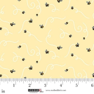 May include: Yellow fabric with a repeating pattern of cartoon bees and white swirly lines. The bees are black and yellow. The fabric is measured in inches.