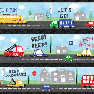 May include: A whimsical illustration of a road scene with various vehicles. The image features a yellow school bus, a green truck, a red fire truck, a blue police car, a yellow taxi, and other cars. Text includes "SLOW DOWN!", "LET'S GO!", "BEEP! BEEP!", "HONK! HONK!", and "KEEP MOVING!"