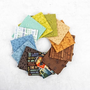 May include: A collection of 10 fabric squares with a variety of nature-themed patterns. The fabric squares are arranged in a circle, with the patterns facing outwards. The patterns include trees, mountains, and animals. The fabric squares are all different colors, including brown, green, blue, and yellow.