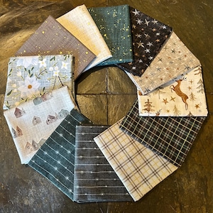 May include: A collection of 10 fabric squares featuring a variety of winter-themed patterns. The fabrics are in shades of brown, green, white, and gold. The patterns include snowflakes, stars, trees, houses, and deer.