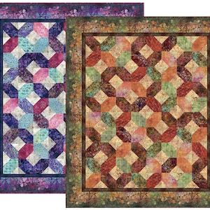 May include: Two rectangular quilts featuring a geometric interlocking pattern. The left quilt displays shades of purple, blue, and pink with a floral border. The right quilt features warm tones of orange, red, and green with a dark brown border.