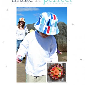May include: A child wearing a blue and white striped bucket hat with a red stripe. The hat is made of fabric and has a wide brim. The child is wearing a white long-sleeved shirt and khaki pants. The hat is available in sizes small to extra large. The image also shows a close-up of a fabric flower with orange, brown, and pink colors.