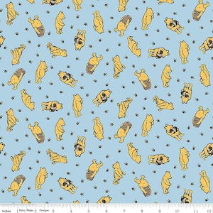 May include: Light blue fabric featuring a repeating pattern of yellow bears, honey pots, and small black bees. The bears are in various poses, some holding honey pots. The design is from Riley Blake Designs.