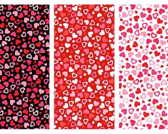 May include: Three fabric swatches with heart patterns. The first has a black background with pink and red hearts. The second has a red background with pink and white hearts. The third has a white background with pink and red hearts.
