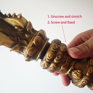 May include: A gold-colored decorative object with intricate details. The object is made of two pieces that screw together. The text "1. Unscrew and stretch 2. Screw and fixed" is visible in the image.