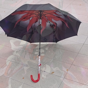 May include: A black and red umbrella with a floral design. The umbrella has a red curved handle and a white and red patterned shaft. The umbrella is open, displaying the red floral design against a black background.