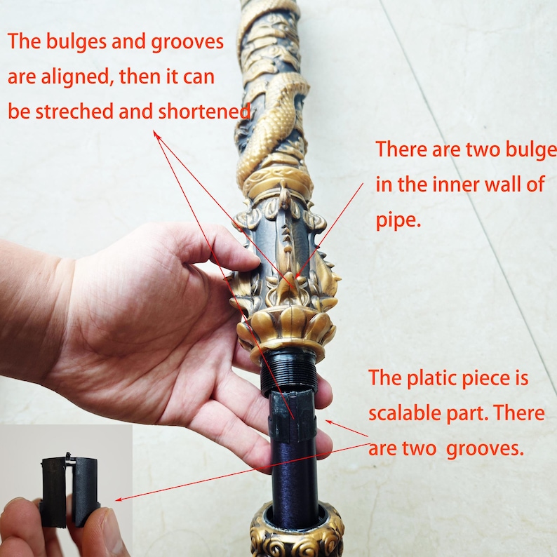 May include: A close-up of a telescopic staff with a gold and black decorative top. The staff is made of metal and has a black plastic piece that can be adjusted to change the length of the staff. The text "The bulges and grooves are aligned, then it can be stretched and shortened" is visible in the image. The text "There are two bulges in the inner wall of pipe." is also visible in the image. The text "The platic piece is scalable part. There are two grooves." is also visible in the image.