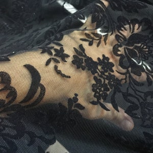 May include: Black sheer fabric with a floral pattern. The fabric is delicate and has a soft, velvety texture.