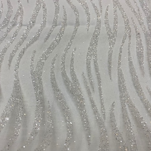 Pode incluir: Tecido branco com estampa de zebra em glitter prata. O tecido é transparente e tem uma textura macia e delicada.