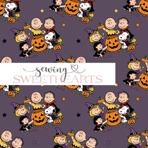 Op de afbeelding: Een donkerpaarse stof met een herhalend patroon van Peanuts-personages in Halloween-kostuums, waaronder Snoopy, Charlie Brown en Lucy, met oranje pompoenen, snoepjes en sterren. De tekst sewing SWEETHEARTS staat in het midden.