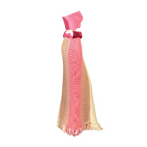 May include: A crocheted skirt and top set in pink, beige, and cream with a fringe trim. The skirt is long and flowing, and the top is a bandeau style.
