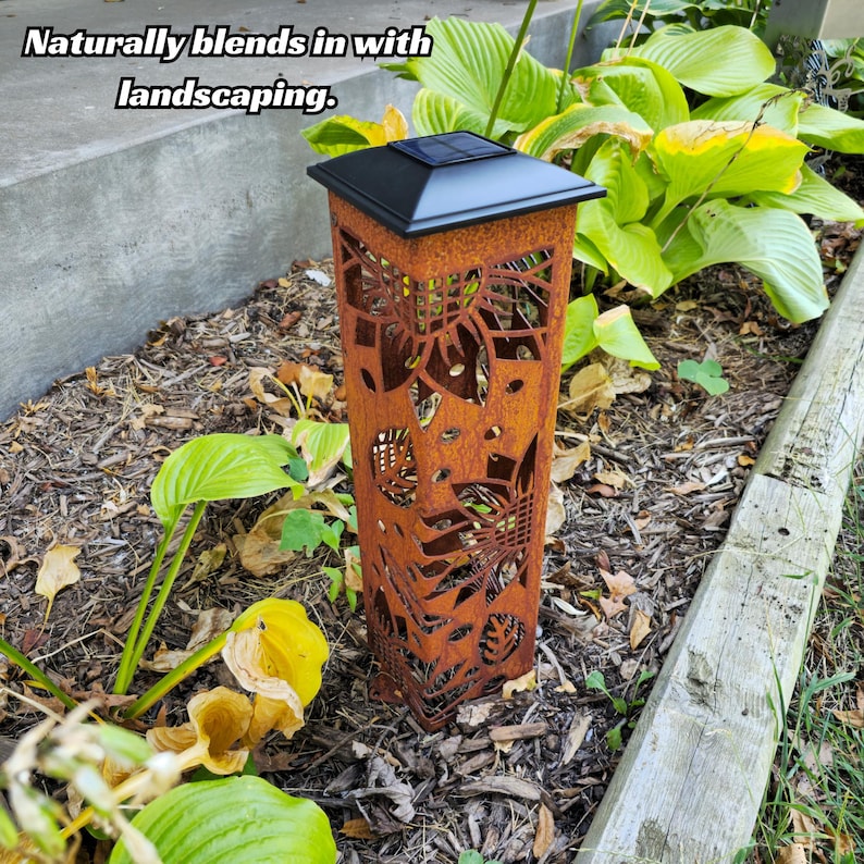 Rust-patina solar garden post blending seamlessly with surrounding plants and landscaping.