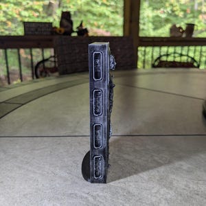 May include: A black and white 3D printed wall decor with a textured surface and a raised design. The decor features a series of rectangular shapes with raised lettering that reads "OPEN", "CLOSE", "PUSH", and "PULL".