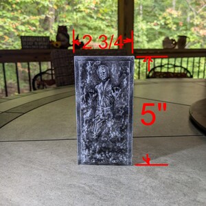 May include: A gray 3D printed model of Han Solo frozen in carbonite. The model is 2 3/4 inches wide and 5 inches tall.