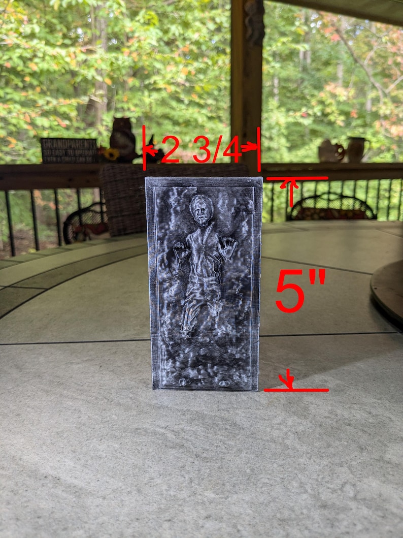 May include: A gray 3D printed model of Han Solo frozen in carbonite. The model is 2 3/4 inches wide and 5 inches tall.