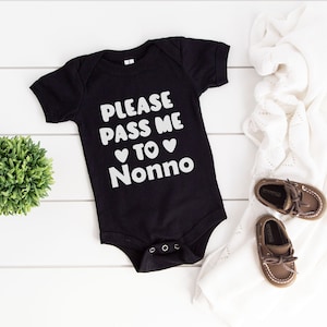 May include: Black baby onesie with white text that reads "Please pass me to Nonno" with two white hearts.