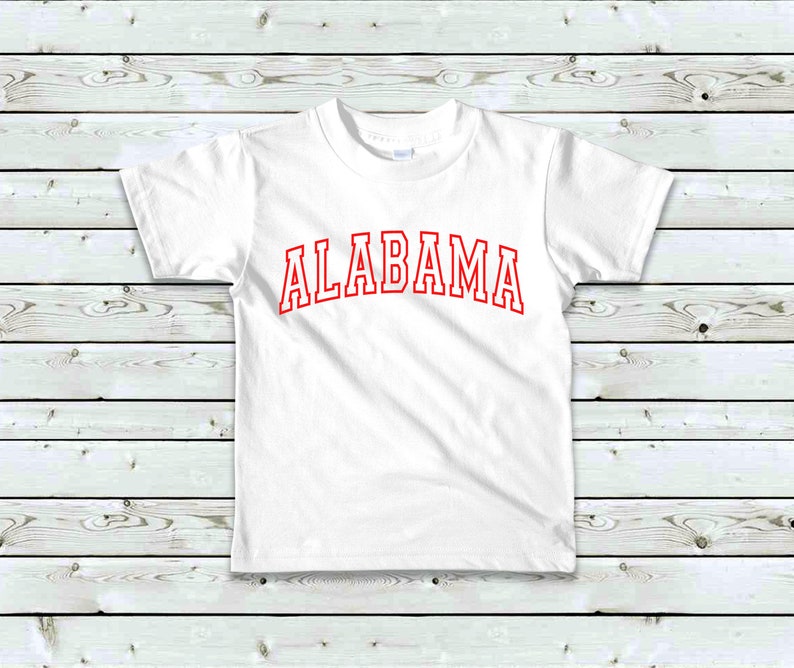 May include: White t-shirt with red text that says "ALABAMA" in a collegiate font.