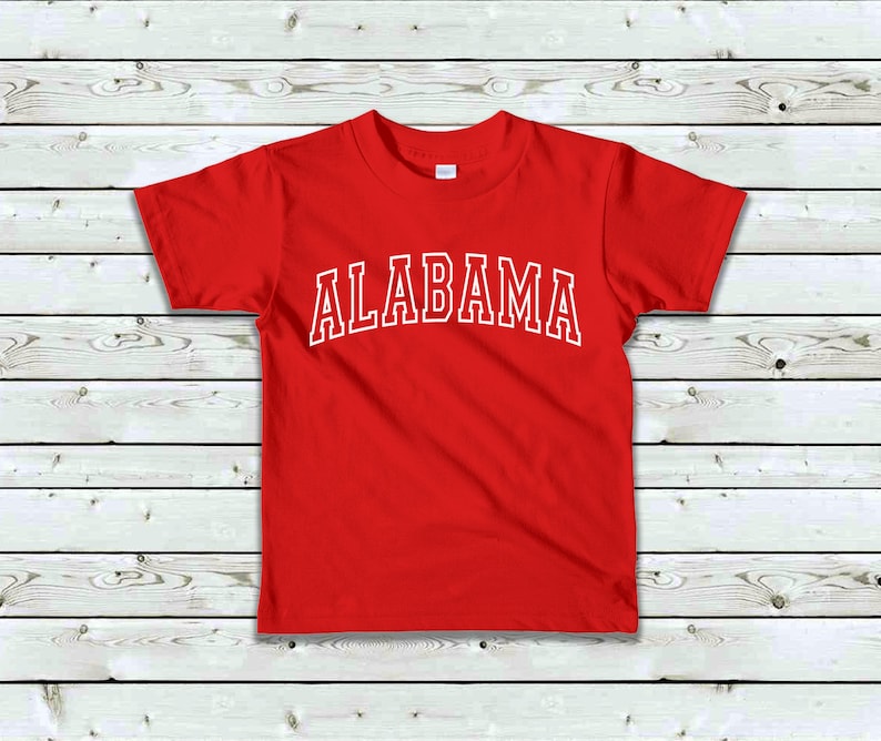May include: Red short-sleeved t-shirt with white text that reads "ALABAMA" in a collegiate font.