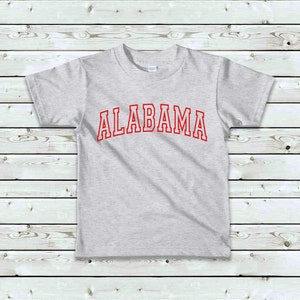 May include: A gray t-shirt with the word "ALABAMA" printed in red on the front.