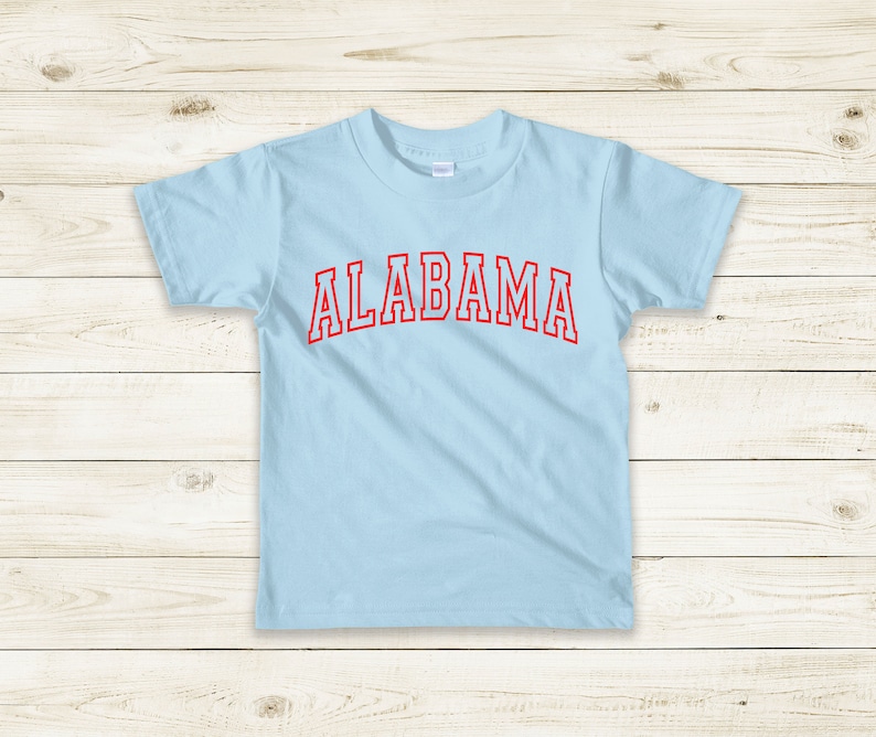 May include: A light blue t-shirt with the word "ALABAMA" printed in red on the front.