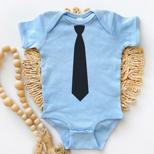 Op de afbeelding: Een lichtblauwe baby romper met een zwarte stropdas print op de voorkant.