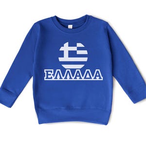May include: A royal blue sweatshirt with a white circle containing the Greek flag and the word "ΕΛΛΑΔΑ" printed below.