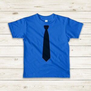 Op de afbeelding: Een blauw t-shirt met een zwarte stropdas-print op de voorkant.