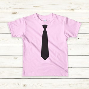 Op de afbeelding: Een roze T-shirt met een zwarte stropdas-print op de voorkant.
