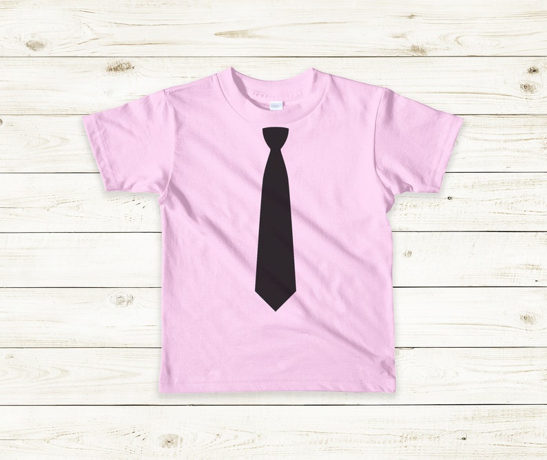 Op de afbeelding: Een roze T-shirt met een zwarte stropdas-print op de voorkant.
