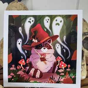 May include: A cartoon raccoon wearing a red witch hat with a white flower and holding a wand. The raccoon is surrounded by white ghosts in a dark forest setting with red mushrooms.