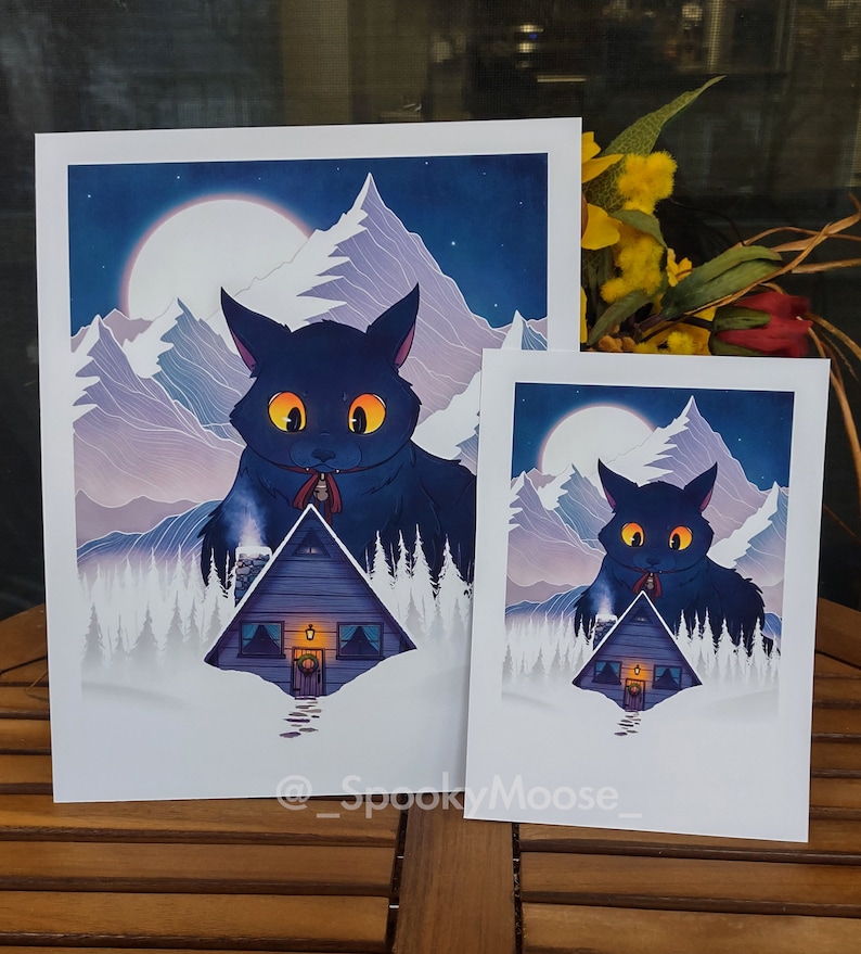 May include: Two illustrations of a black cat standing in front of a small cabin in a snowy mountain landscape. The cat is wearing a red scarf and has glowing yellow eyes. The moon is visible in the night sky. The text "@SpookyMoose" is at the bottom of the image.