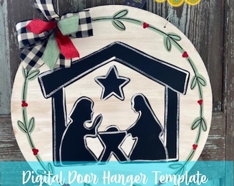 May include: A round wooden door hanger with a white background and a black silhouette of the nativity scene. The scene includes Mary, Joseph, and the baby Jesus in a manger. The hanger is decorated with a green wreath with red berries and a black and white checkered bow.