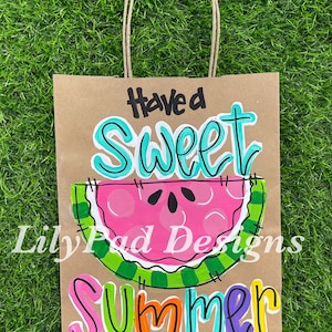 May include: A brown paper gift bag with a painted watermelon design and the text "Have a Sweet Summer".