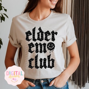 May include: Beige t-shirt with the text "elder emo club" in a black, gothic font. The design includes a dripping smiley face. The shirt has short sleeves and a relaxed fit.