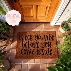 May include: A brown coir doormat with the text "Check ya vibe before you come inside" in black lettering.