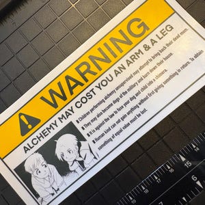 May include: A white ceramic mug with a black handle and the text "But First, Coffee" in a handwritten style. The mug is likely for hot beverages and has a glossy finish.