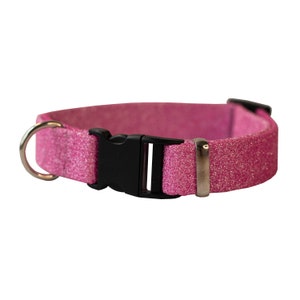 Op de afbeelding: Roze glitter hondenhalsband met een zwarte gesp en een zilveren D-ring.