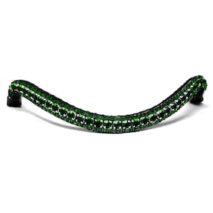 May include: A green crystal browband for horses. The browband is made of black leather and is decorated with emerald green crystals.
