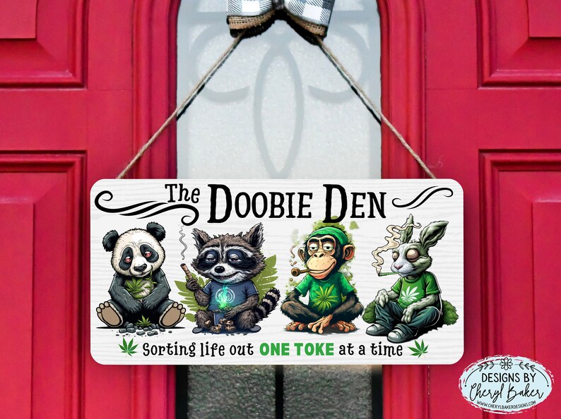 May include: A white wooden sign with the text "The Doobie Den" and a cartoon image of a panda, raccoon, monkey, and rabbit smoking. The sign also says "Sorting life out one toke at a time".