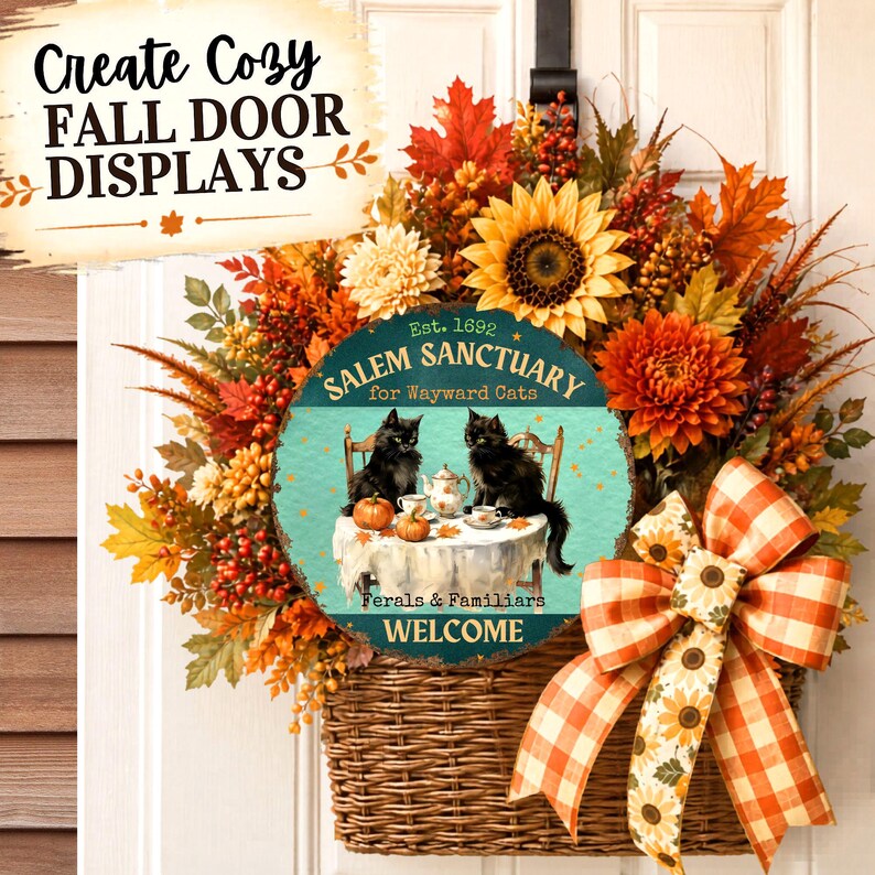May include: A fall-themed door basket wreath featuring orange, yellow, and red autumn leaves, sunflowers, and berries. A round sign in the center reads: Est. 1692 SALEM SANCTUARY for Wayward Cats, FERALS & FAMILIARS WELCOME, with two black cats.