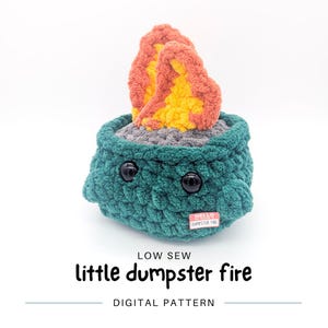 May include: A crocheted plush toy shaped like a dumpster fire. The toy is green with a gray base and orange and yellow flames. The toy has black eyes and a tag that says "Hello, I'm a dumpster fire".