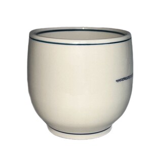 May include: A white ceramic mug with a blue rim and a thin blue line design. The mug is round and has a slightly flared lip.
